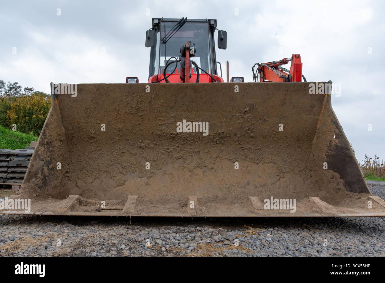 Poggiare il veicolo da costruzione prima dell'inizio dei lavori, simboleggiando la pianificazione e l'avanzamento Foto Stock