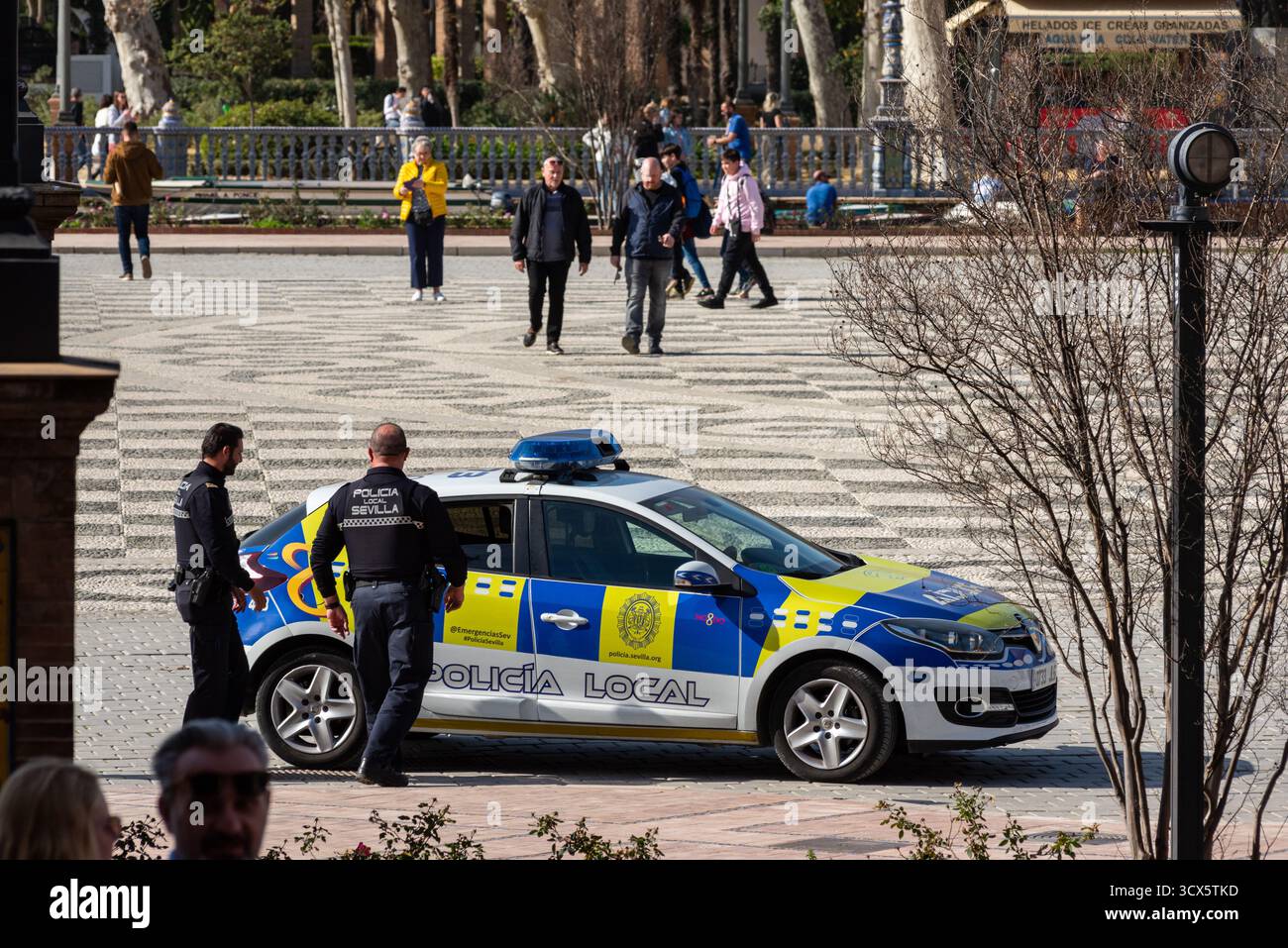 Gli agenti di polizia municipali arrivano a Plaza de España in cerca di venditori ambulanti senza licenza per vendere merci ai turisti a Siviglia, Spagna. Foto Stock