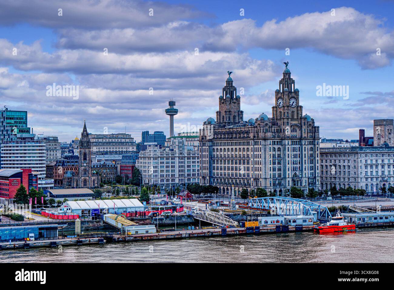 LIVERPOOL, INGHILTERRA - 18 agosto 2025: Lo skyline di Liverpool presenta un mix di storici magazzini in mattoni e moderne torri di vetro che fiancheggiano il fiume Mersey Foto Stock
