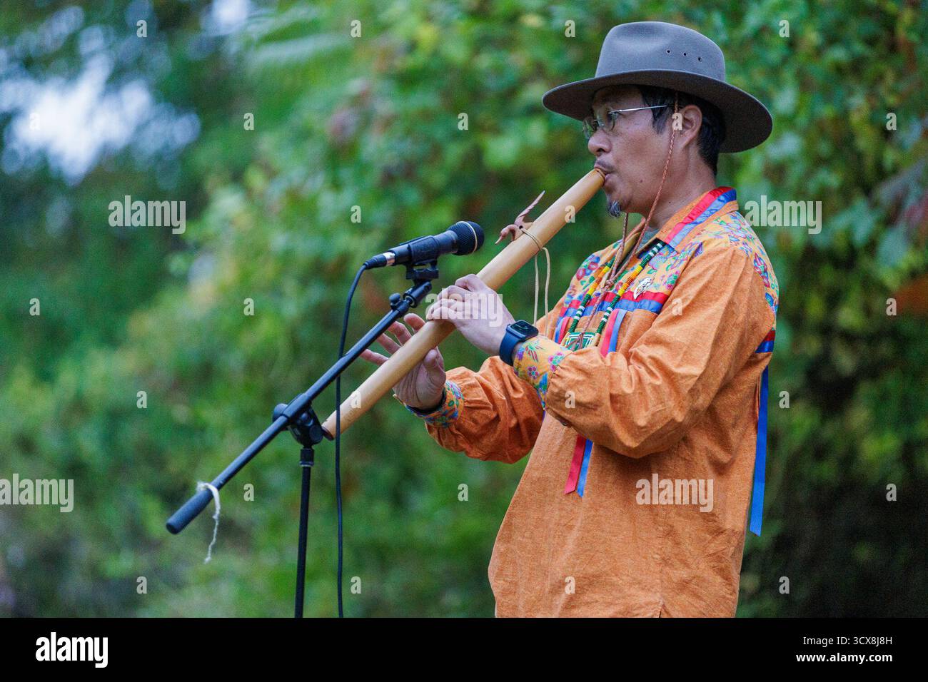 Rochester, New York, Stati Uniti. 13 ottobre 2025. Proprio come l'alba JEFFERSON SVENGSOUK suona un flauto per aprire la cerimonia dell'alba per la celebrazione del giorno dei popoli indigeni a Rochester, NY. Crediti: ZUMA Press, Inc./Alamy Live News Foto Stock