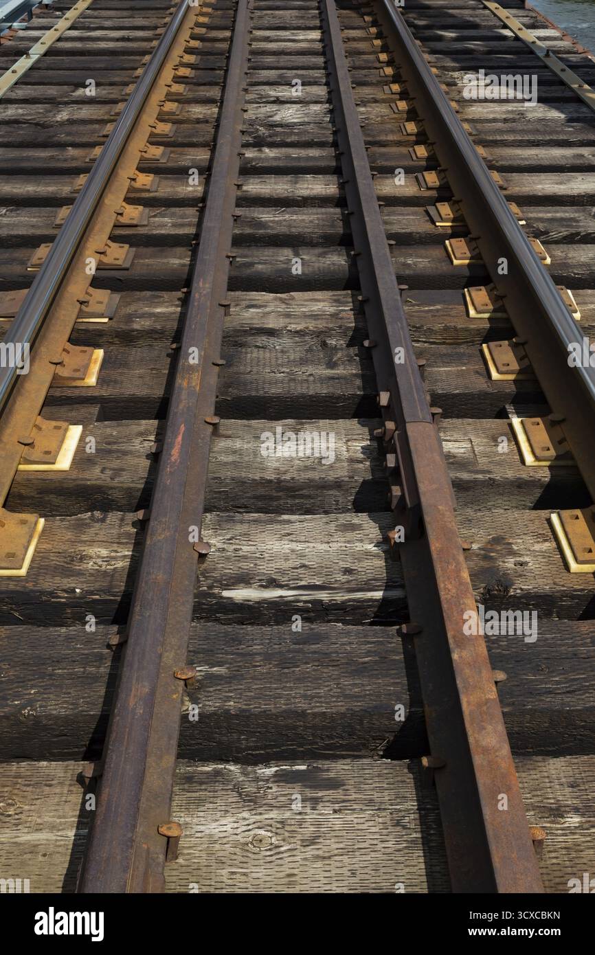 I binari ferroviari erano disposti su un ponte di Pratt e supportati da collegamenti ferroviari in legno pesante macchiati di petrolio, Quebec, Canada Foto Stock
