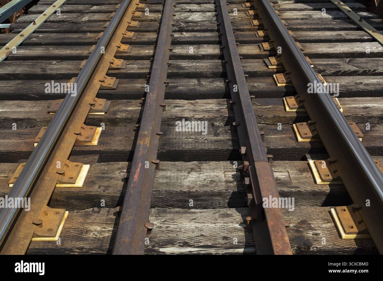 I binari ferroviari erano disposti su un ponte di Pratt e supportati da collegamenti ferroviari in legno pesante macchiati di petrolio, Quebec, Canada Foto Stock