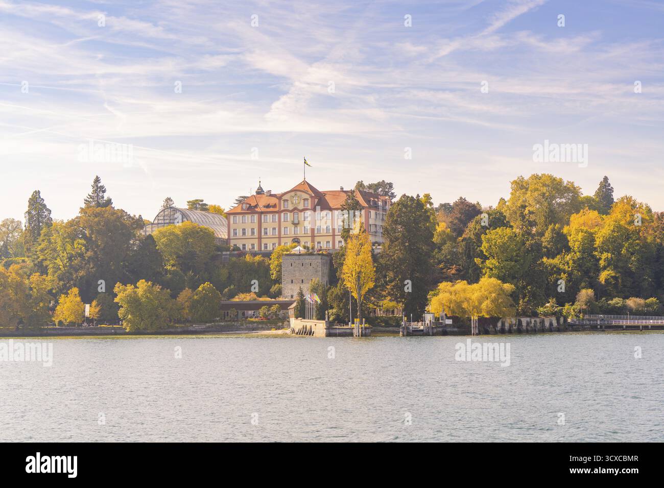 Castello circondato da alberi autunnali sul lago sotto un cielo blu, isola di Mainau, lago di Costanza, Germania Foto Stock