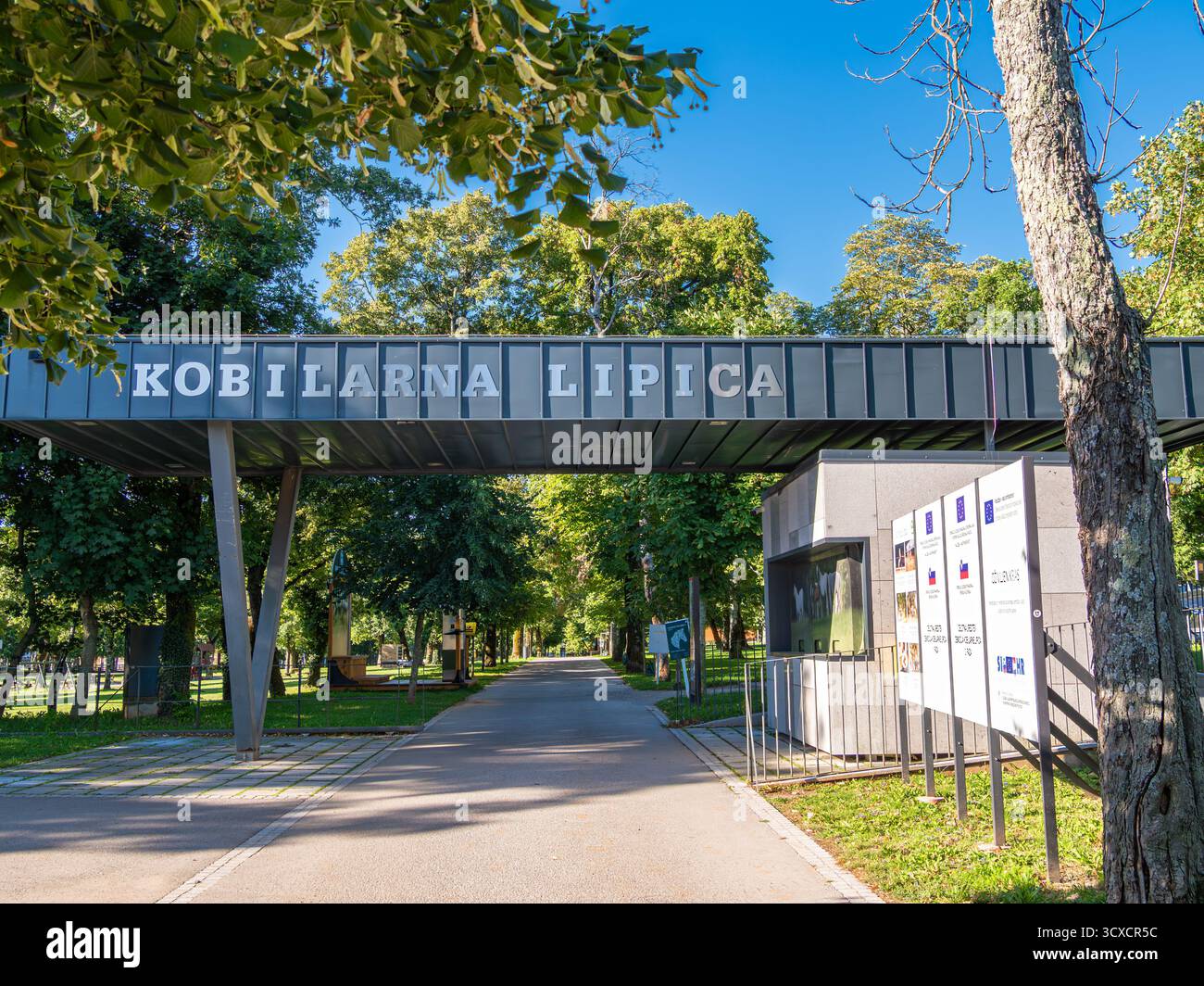 Lipica, Slovenia - 8 agosto 2025: Ingresso al allevamento di cavalli Lipica con segnaletica e alberi. Foto Stock