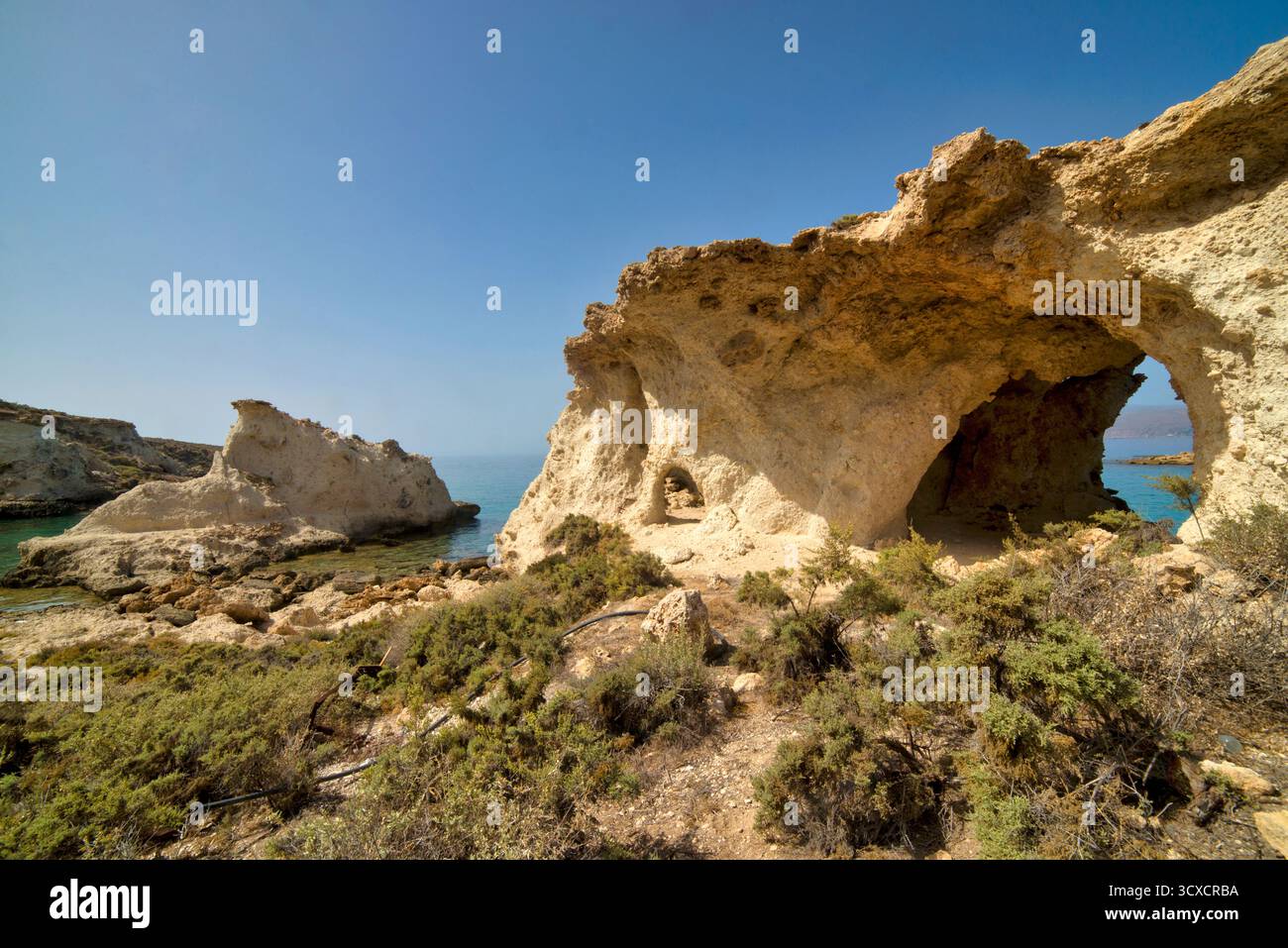 Rocky Coastal Arch con Vista Oceano e tessuti illuminati dal sole Foto Stock