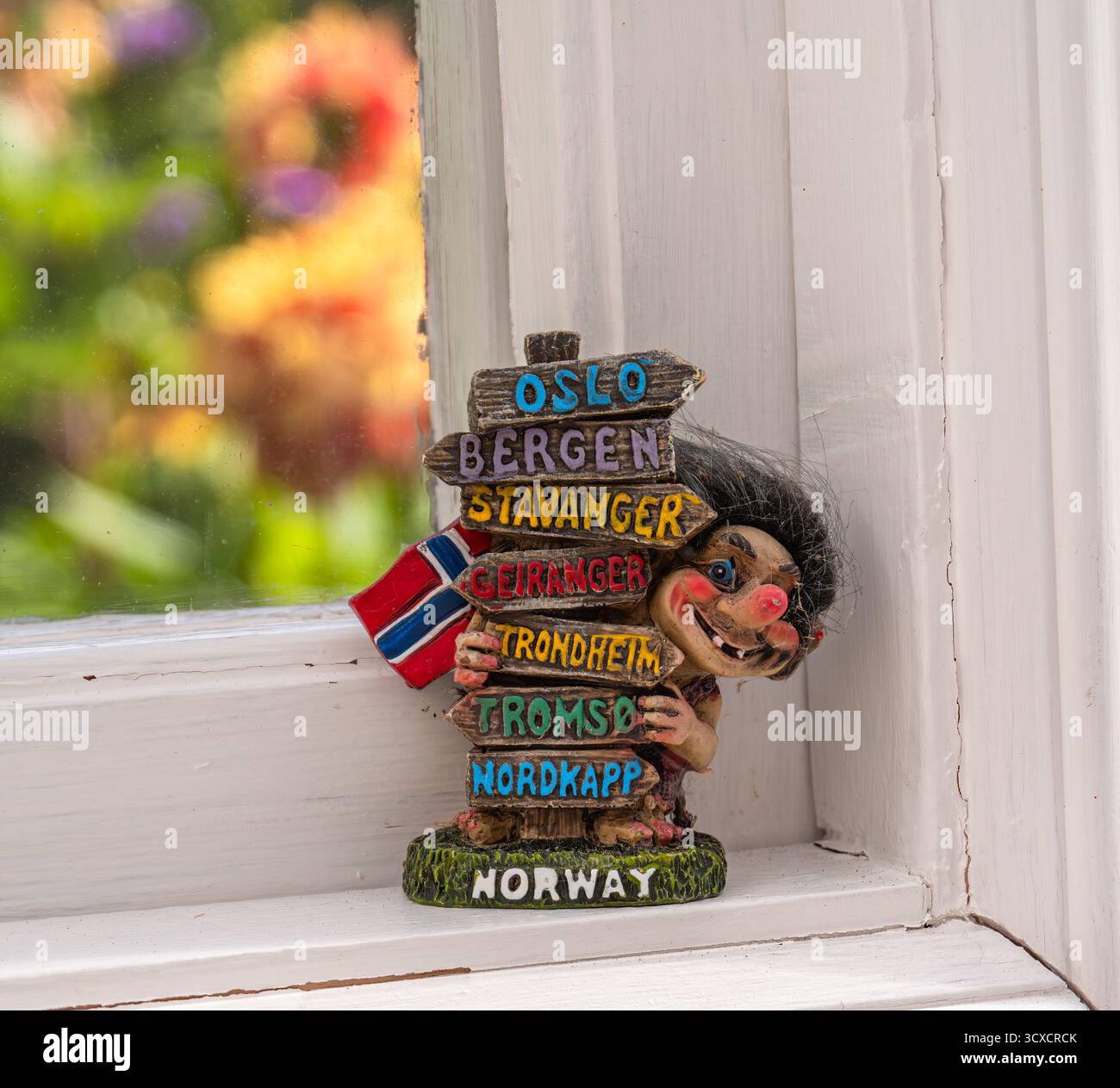Nykvarn, Svezia - 3 settembre 2025: Una colorata statuetta di troll norvegese con un cartello con i nomi delle città. Foto Stock