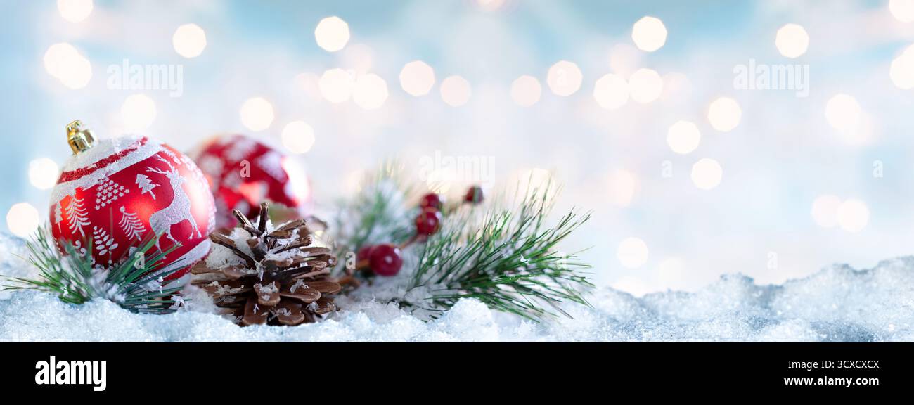 Ornamenti natalizi rossi e pinne in scena innevata Foto Stock