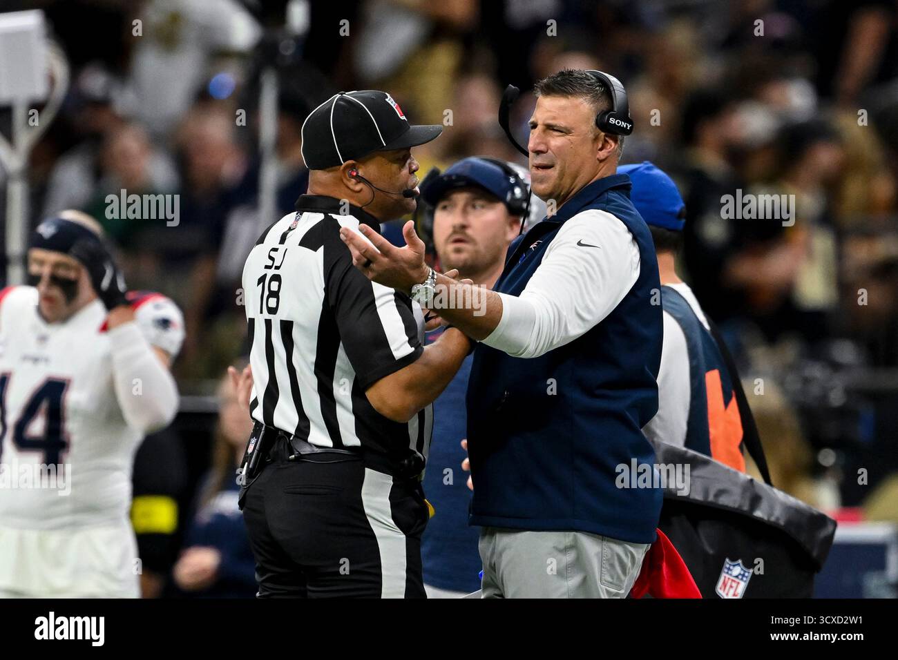 New England Patriots head coach Mike Vrabel speaks with side judge Clay Reynard (18) during the first half of an NFL football game against the New Orleans Saints, Sunday, Oct. 12, 2025, in New Orleans. (AP Photo/Maria Lysaker) Foto Stock