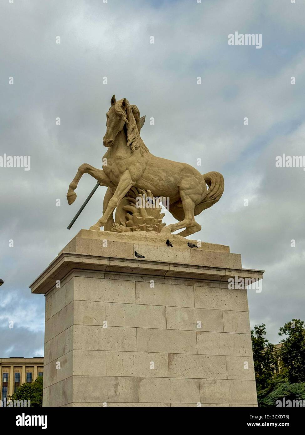 Vista dall'angolo basso di una monumentale statua di cavallo in pietra vicino a Trocadéro, Parigi, sotto un cielo nuvoloso e drammatico. - Immagine stock catturata con smartphone