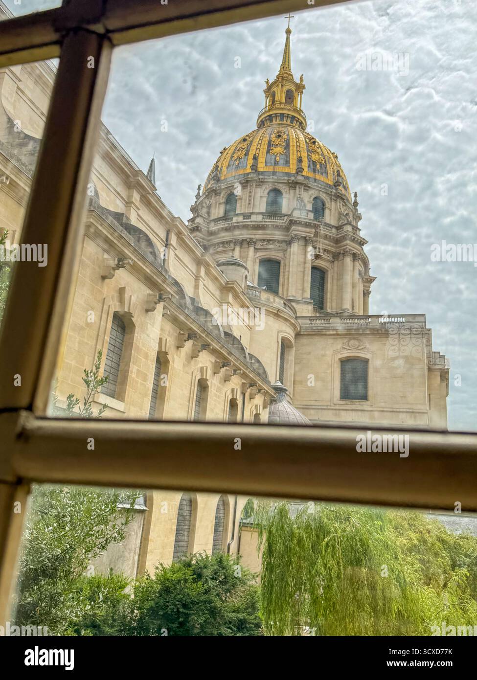 Vista del Duomo degli Invalides incorniciato da una griglia all'interno dell'Hôtel des Invalides, Parigi, sotto un cielo nuvoloso - Immagine stock catturata con smartphone
