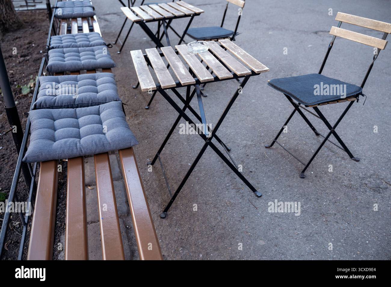 Area salotto vuota con sedie in acciaio nero sulla strada di un campus universitario. Foto Stock