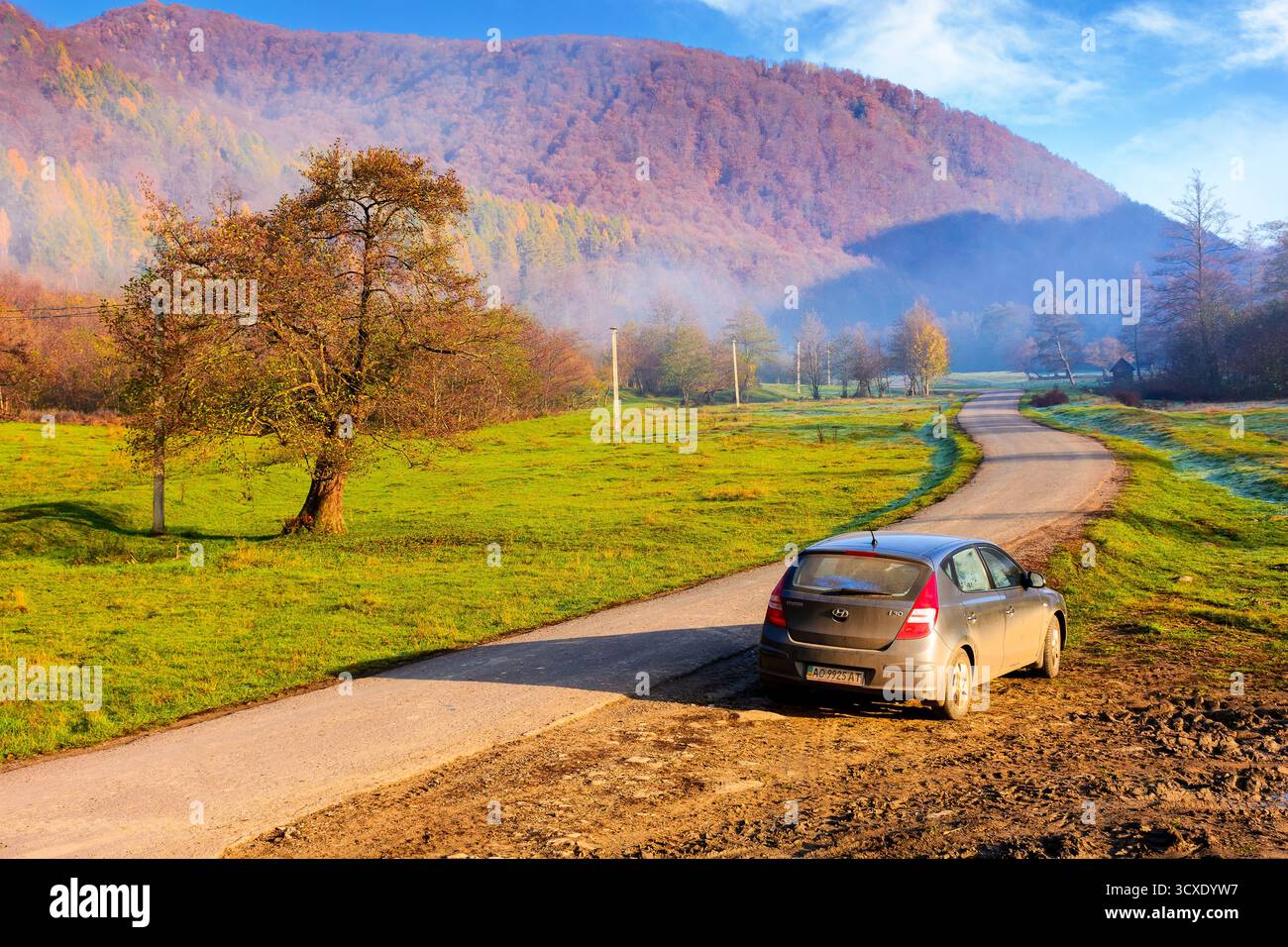 perechyn, ucraina - 10 novembre 2020: auto vicino alla strada asfaltata in autunno. viaggio attraverso il paesaggio di campagna montano dell'ucraina con la nebbia mattutina. cappello hyundai Foto Stock