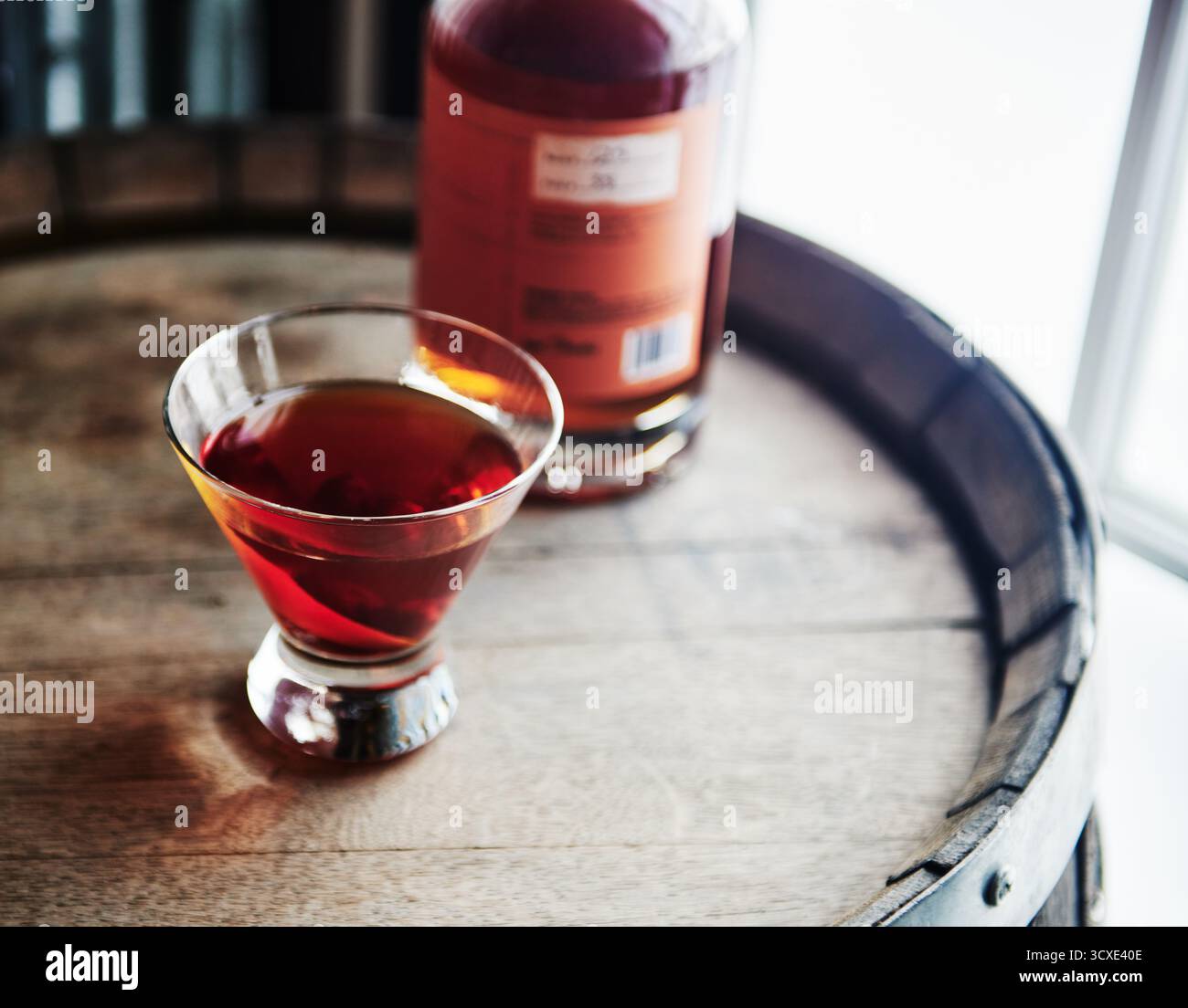 Cocktail di whiskey seduto in cima a un vecchio barile di whisky Foto Stock