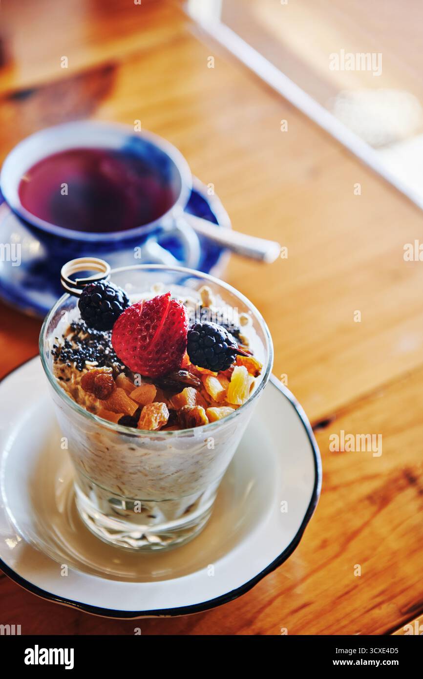Colazione con parfait di frutta e una tazza di tè Foto Stock
