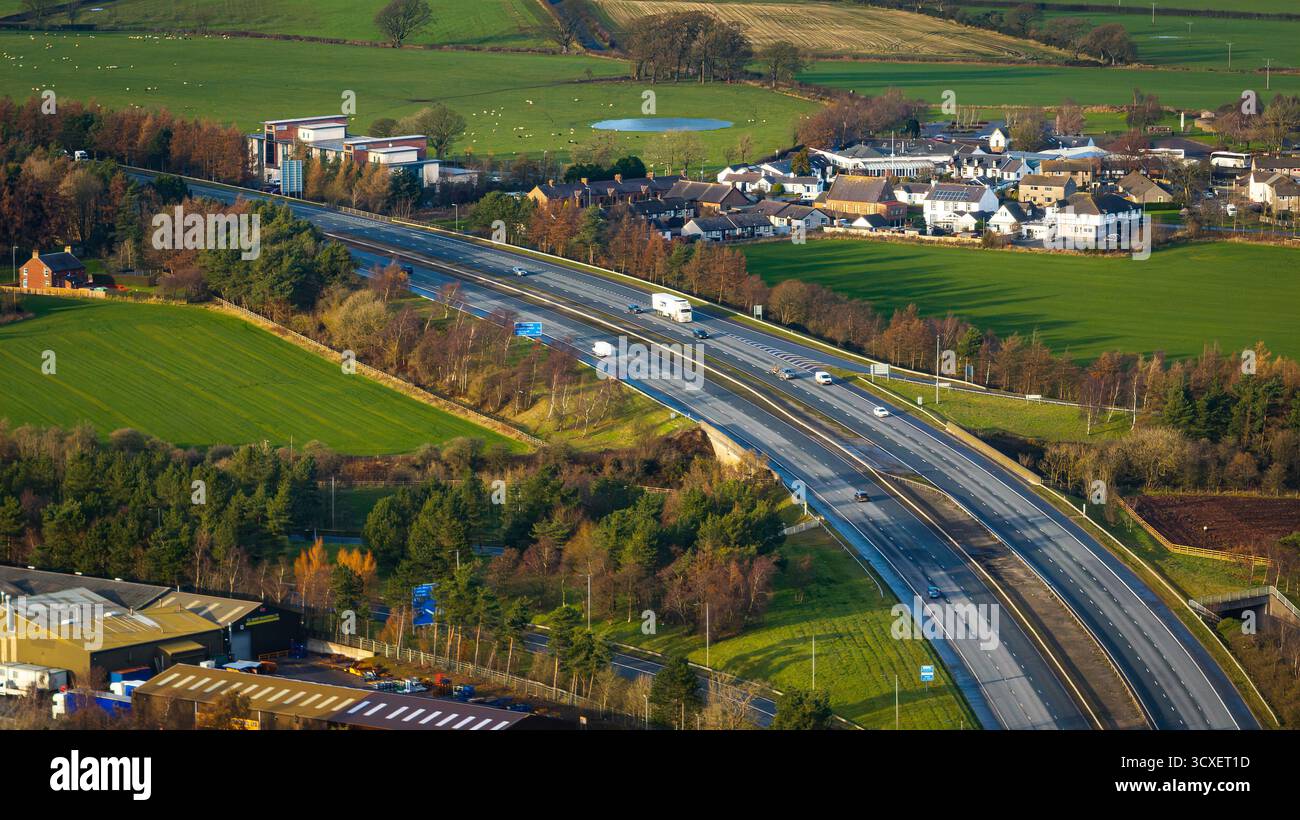 Veduta aerea dell'autostrada M74 vicino a Gretna sul confine tra Scozia e Inghilterra, mostrando la principale via di trasporto che taglia i terreni rurali di Dumfri Foto Stock
