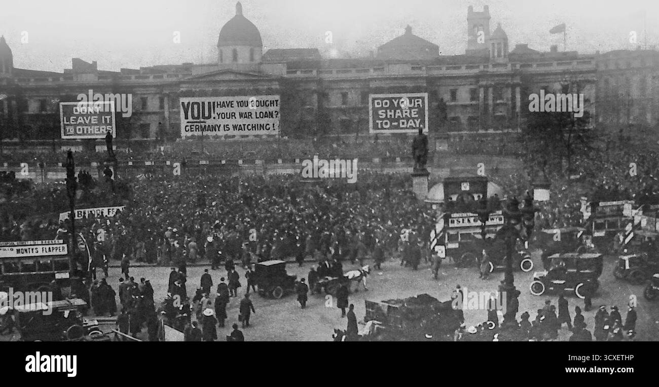 Da le Miroir, 4 marzo 1917, mostra Trafalgar Square a Londra durante l'ultimo giorno della campagna di prestito di guerra britannica. Grandi folle si sono riunite davanti alla Galleria Nazionale, che è stata drappeggiata da enormi striscioni che invitavano i cittadini ad aderire al prestito con slogan come "Do Your Share Today" e "la Germania sta guardando". Questa fotografia evidenzia la portata della propaganda in tempo di guerra e la mobilitazione delle finanze pubbliche per sostenere lo sforzo bellico britannico. Foto Stock