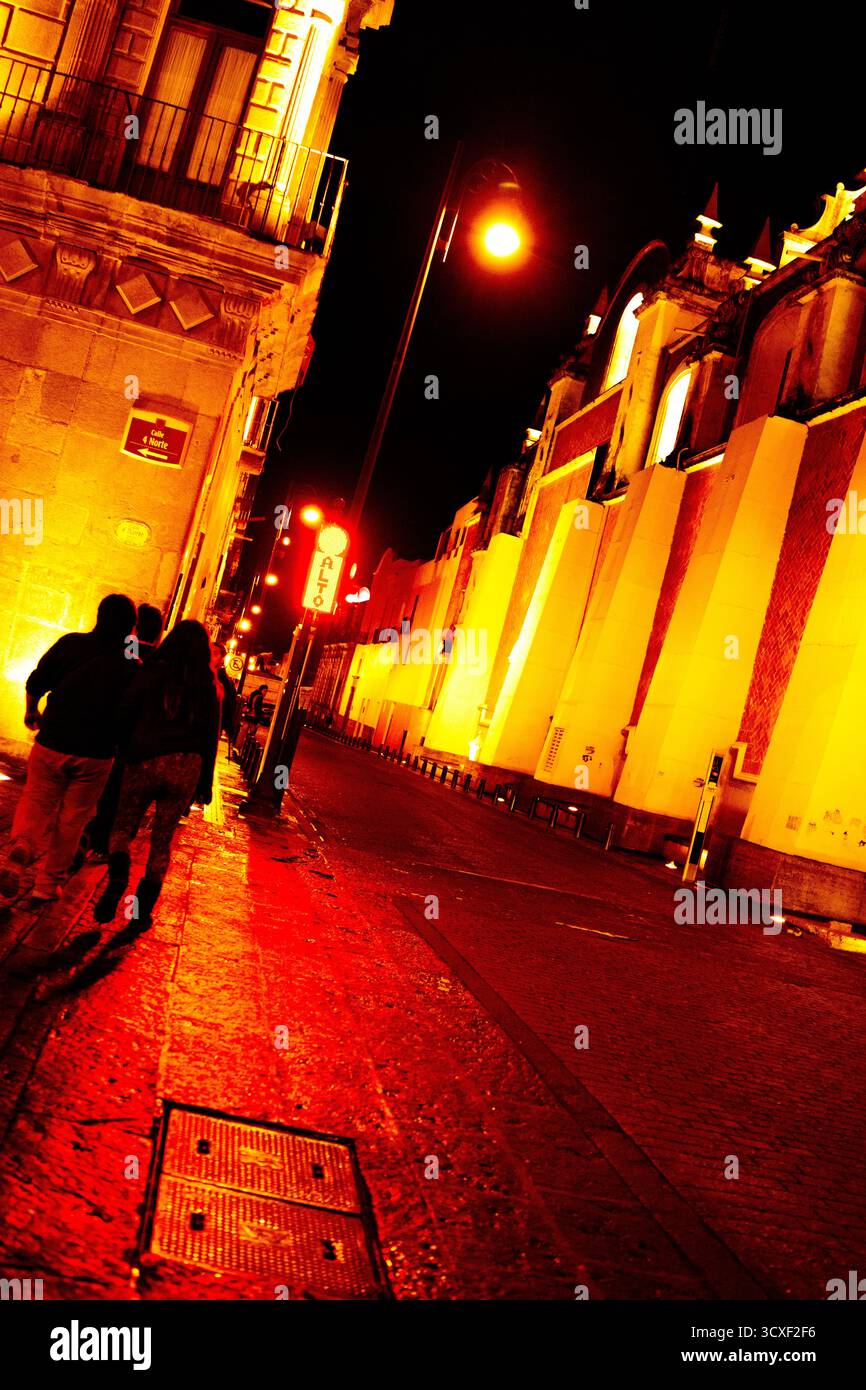 Di notte nelle strade di Puebla de Los Angeles, Messico, con luci calde e vecchi edifici, ritratti concettualmente Foto Stock