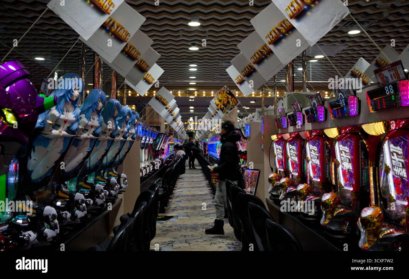 File di colorate macchine pachinko con personaggi Neon Genesis Evangelion riempiono una sala giochi di Osaka Foto Stock