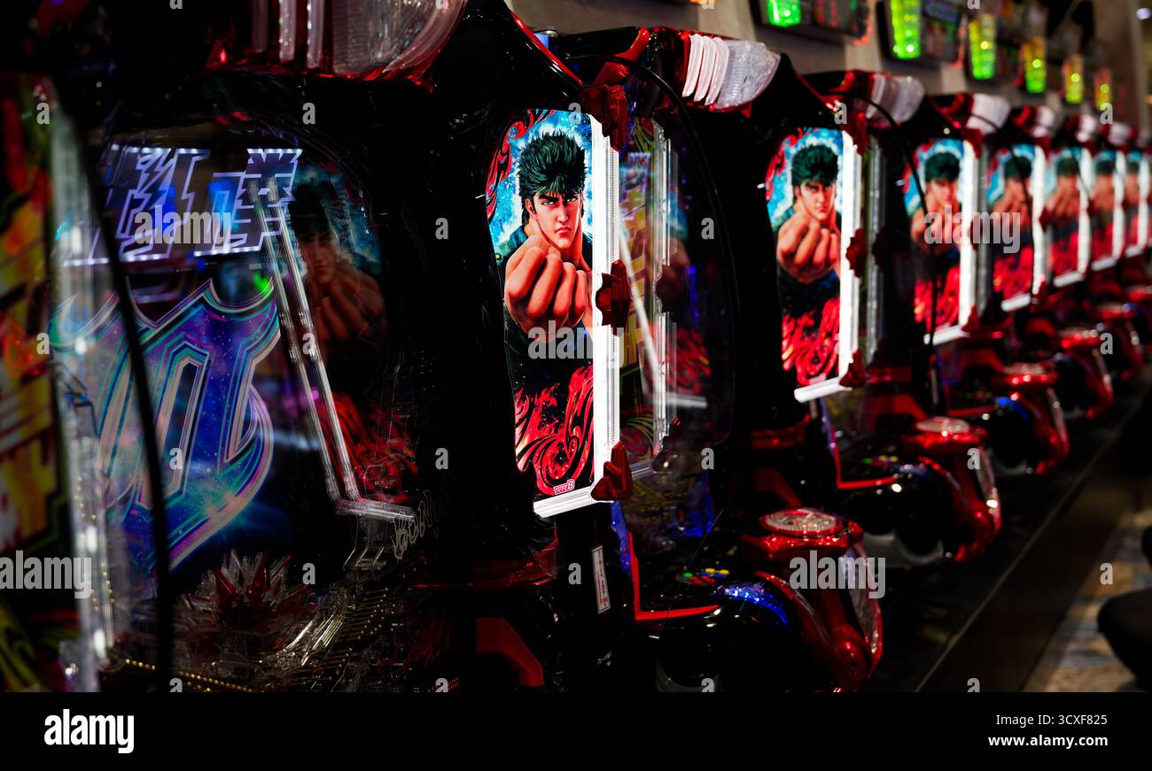Una fila di macchine pachinko Fist of the North Star illuminate fiancheggia una sala giochi di Osaka Foto Stock