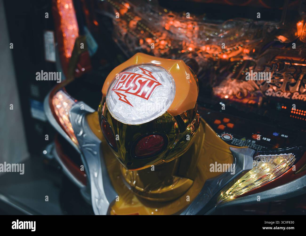 Pulsante "Push" antropomorfo dorato su una macchina pachinko a Osaka Foto Stock