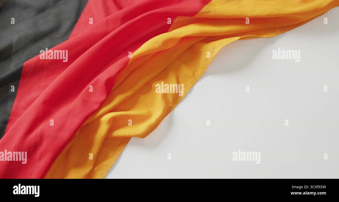 Stoffa tricolore con strisce nere rosse gialle su superficie bianca liscia, spazio di copia Foto Stock