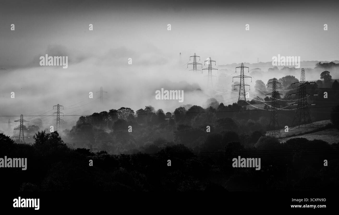 West Yorkshire, Regno Unito. 12 ottobre 2025. Meteo Regno Unito.Halifax, West Yorkshire, Regno Unito. Le nebbie autunnali nella valle incorniciano il paesaggio , colline vicine, brughiere, e piloni marcianti nei pressi di Halifax, West Yorkshire, domenica mattina di ottobre. Crediti: Immagini di mulini a vento/Alamy Live News Foto Stock