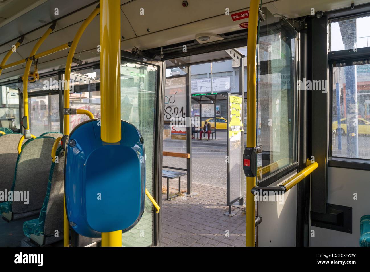 Vista interna di un moderno autobus cittadino di Atene, con posti a sedere, corrimano e luce naturale attraverso le finestre durante il giorno Foto Stock
