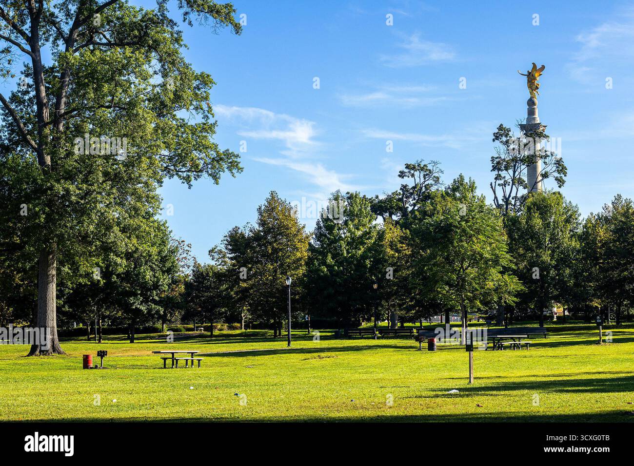 Pelham Bay Park, Bronx, New York City, con il Bronx Victory Memorial sullo sfondo e tavoli da picnic e alberi in primo piano. Foto Stock