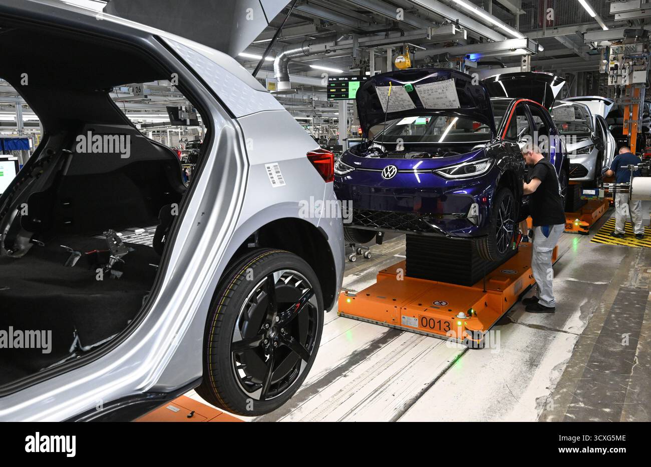 Zwickau, Germania. 13 ottobre 2025. I veicoli elettrici ID.3 e Cupra Born sono assemblati nello stabilimento Volkswagen di Zwickau. Finora, sei modelli Volkswagen, Audi e Cupra sono usciti dalla linea di produzione nello stabilimento di Sassonia. Lo stabilimento di Zwickau non funziona attualmente a piena capacità. La capacità è di oltre 300.000 veicoli all'anno; secondo la direzione, attualmente è poco più di 200.000. Crediti: Hendrik Schmidt/dpa/Alamy Live News Foto Stock