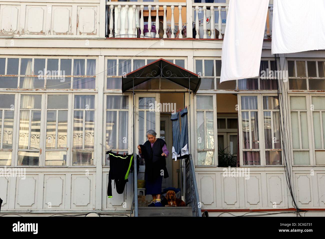 Una vecchia donna che fa il bucato per asciugare a Tbilisi, Georgia Foto Stock