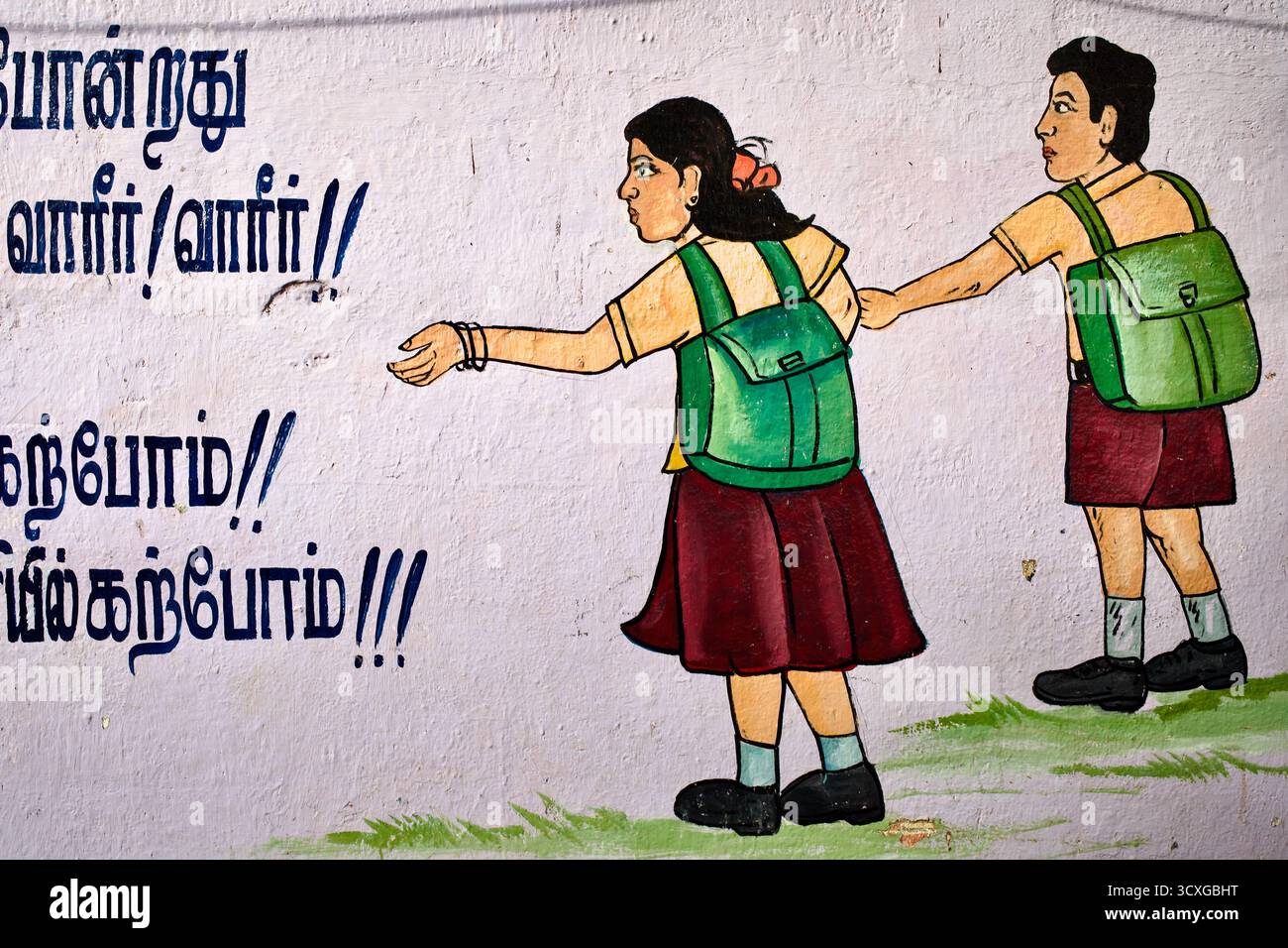 Murale a Chennai, Tamil Nadu, raffigurante scolari con zaini che promuovono l'educazione e la consapevolezza della sicurezza nella scrittura tamil. Foto Stock
