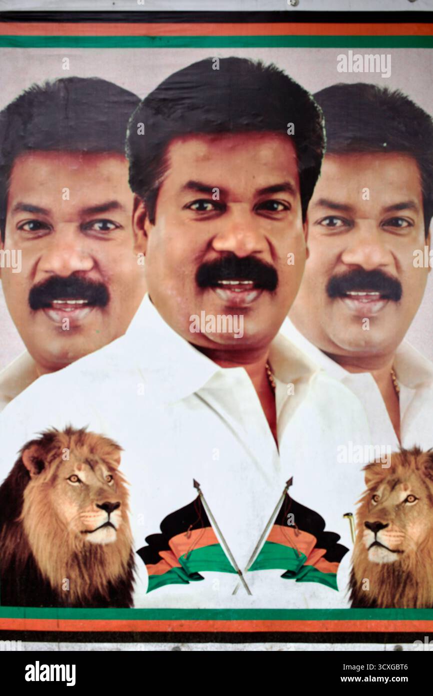 Manifesto politico tamil con un leader maschile affiancato da leoni e bandiere del partito, fotografato a Tamil Nadu, India. Foto Stock