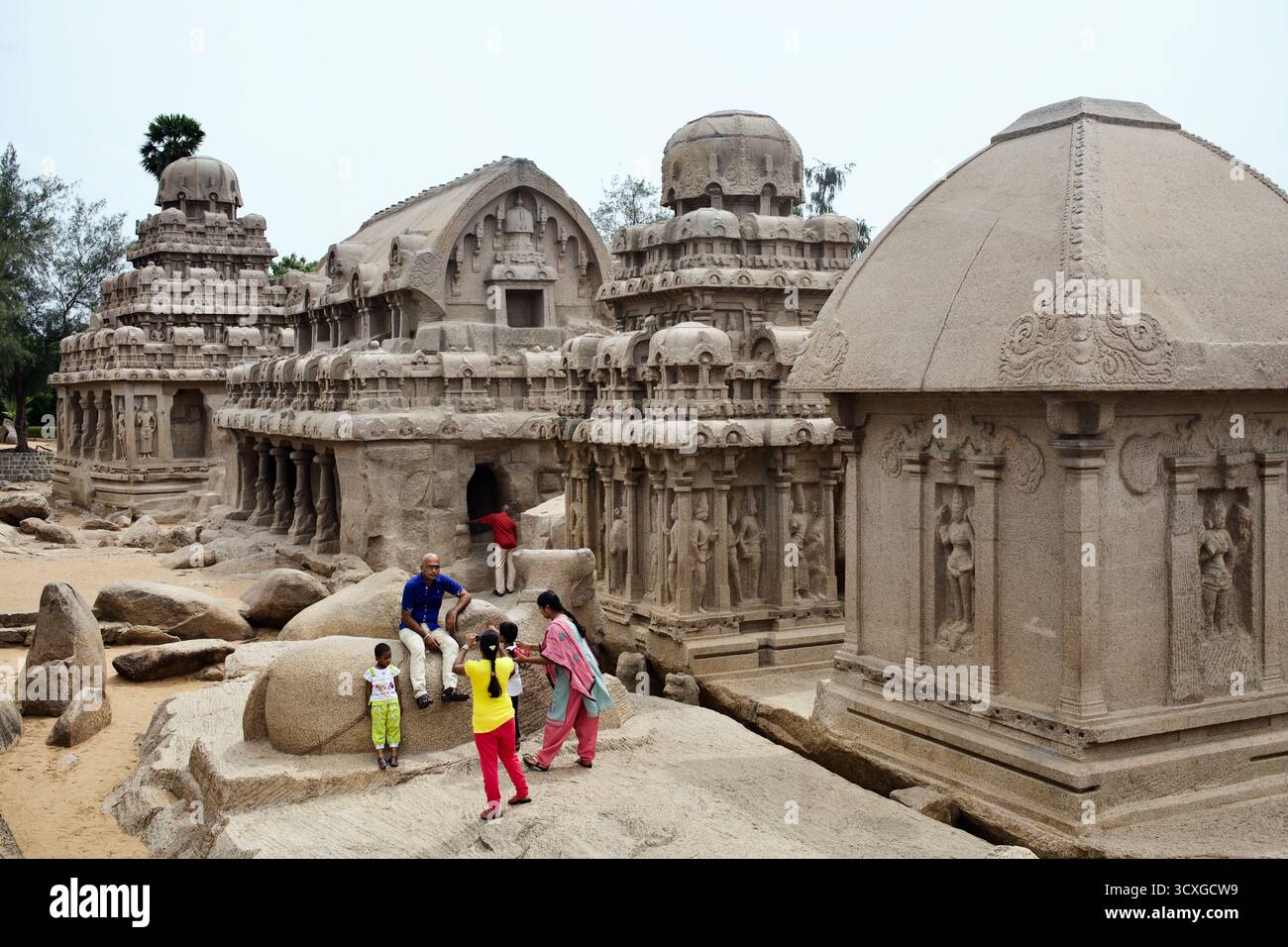 Visitatori tra i Pancha Rathas (cinque Rathas) a Mahabalipuram, Tamil Nadu, templi monolitici scavati nella roccia risalenti al periodo Pallava del VII secolo. Foto Stock