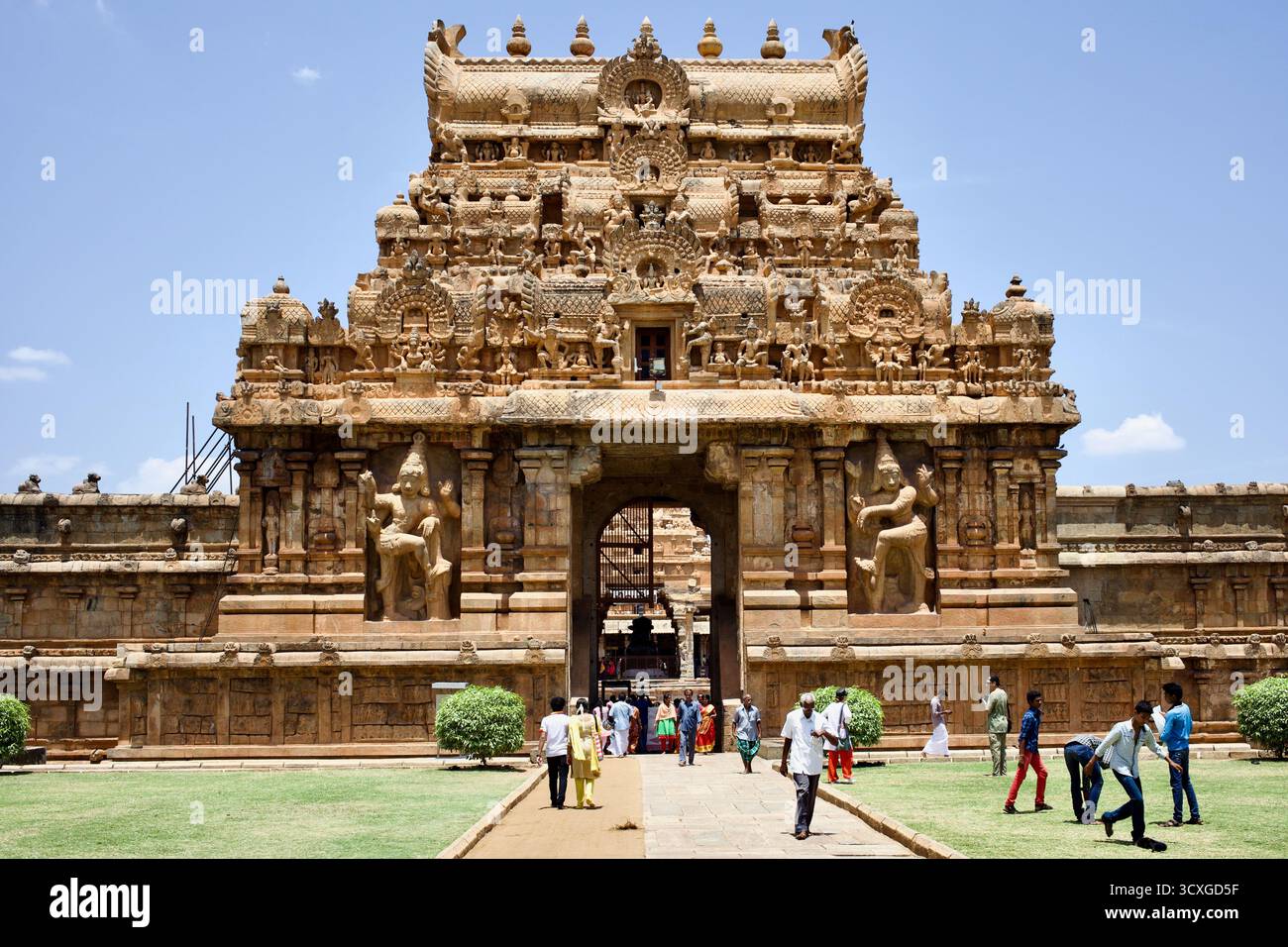 I visitatori camminano attraverso uno dei cancelli del complesso del Tempio di Brihadisvara a Thanjavur, Tamil Nadu, India, un capolavoro dell'architettura Chola. Foto Stock