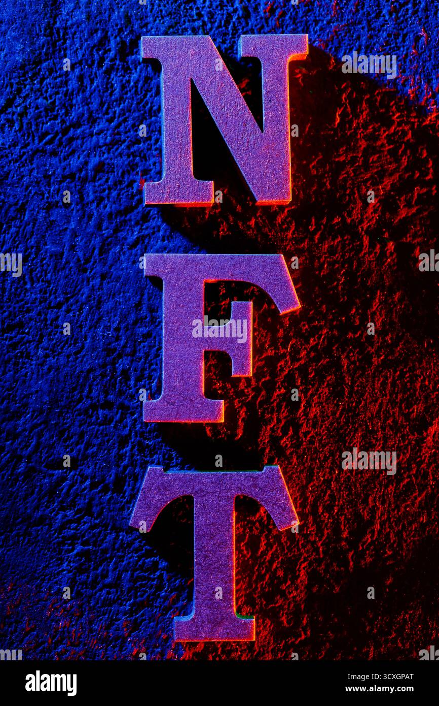 Lettere NFT sulle pareti testurizzate con illuminazione blu e rossa al neon Foto Stock