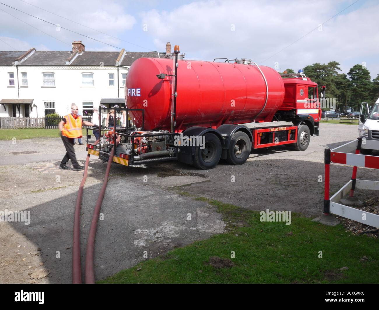 Autocarro cisterna antincendio con equipaggio in zona residenziale Foto Stock