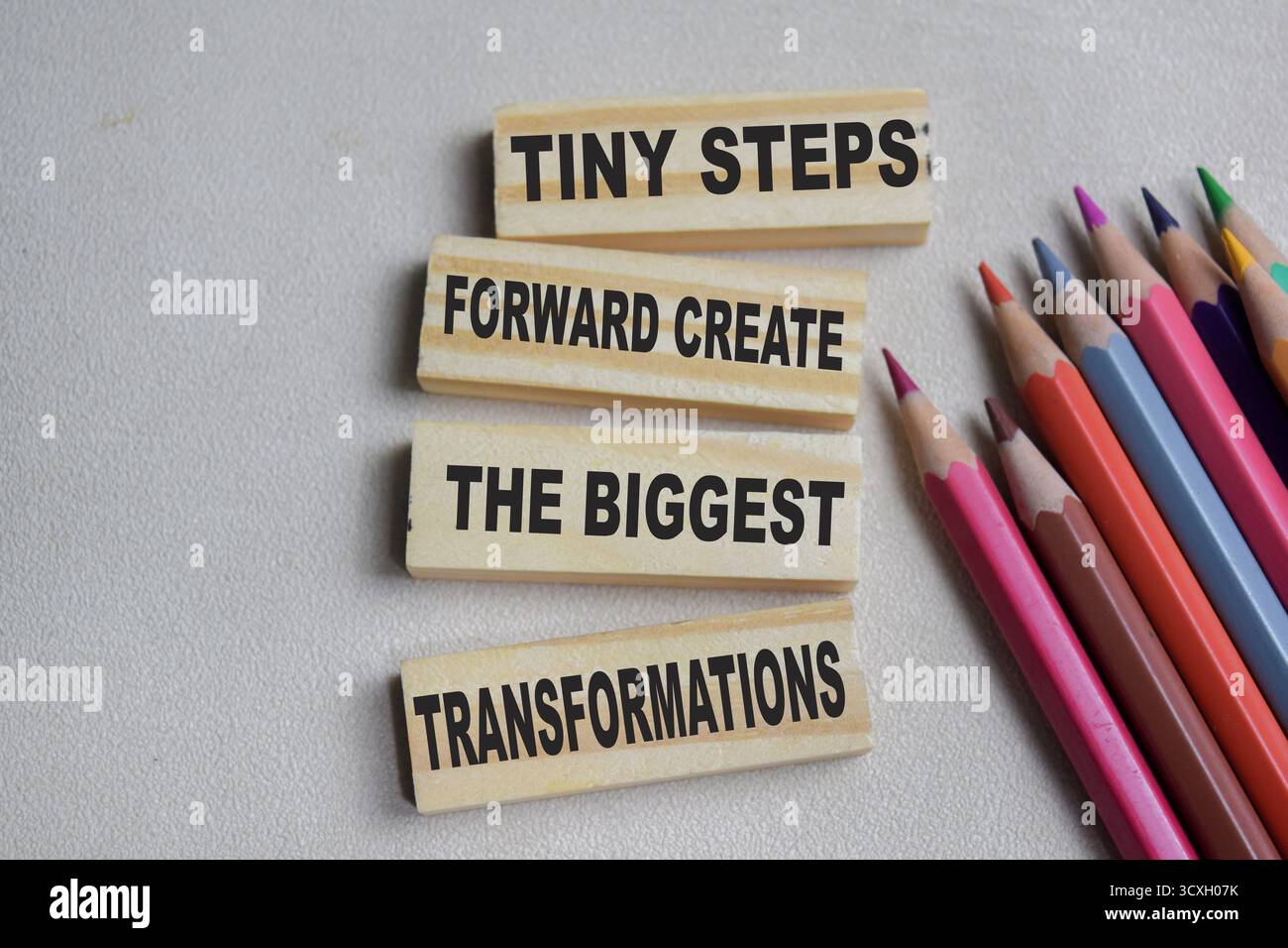 Piccoli passi in avanti creano le trasformazioni più grandi sui cubi di legno impilati sul tavolo. Business e finanza Foto Stock