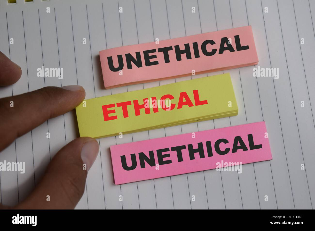 Concetto di scrittura etica o non etica su appunti adesivi isolati su un tavolo di legno. Foto Stock