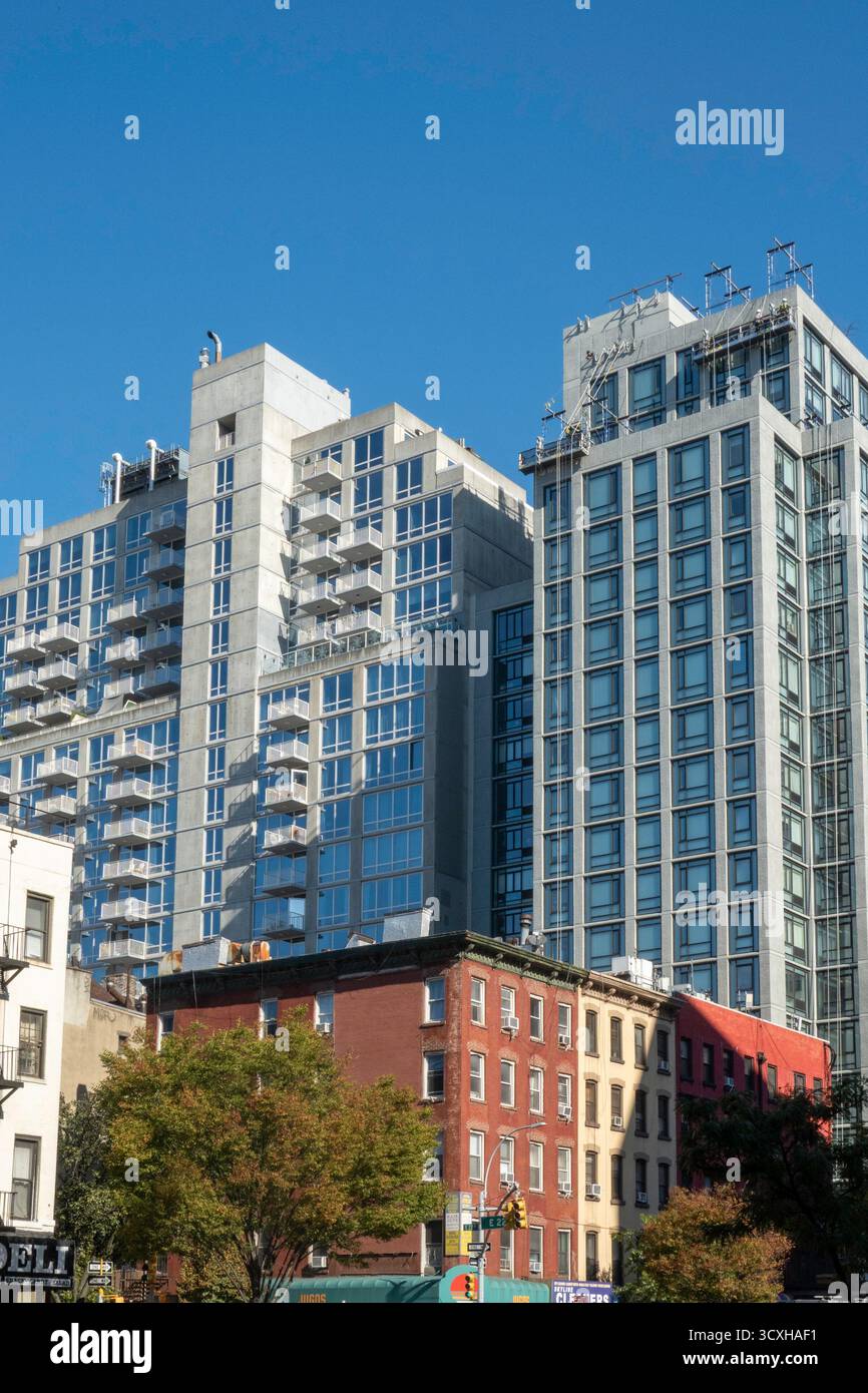 Gli alti condomini sulla E. 23rd St. Sono in netto contrasto con le basse pietre arenarie lungo la First Avenue, 2025, New York City, Stati Uniti Foto Stock