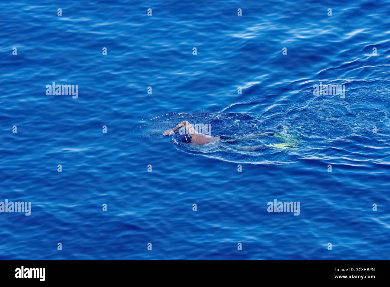 Nuota con una pagaia nel mare. Il mare e il nuotatore Foto Stock