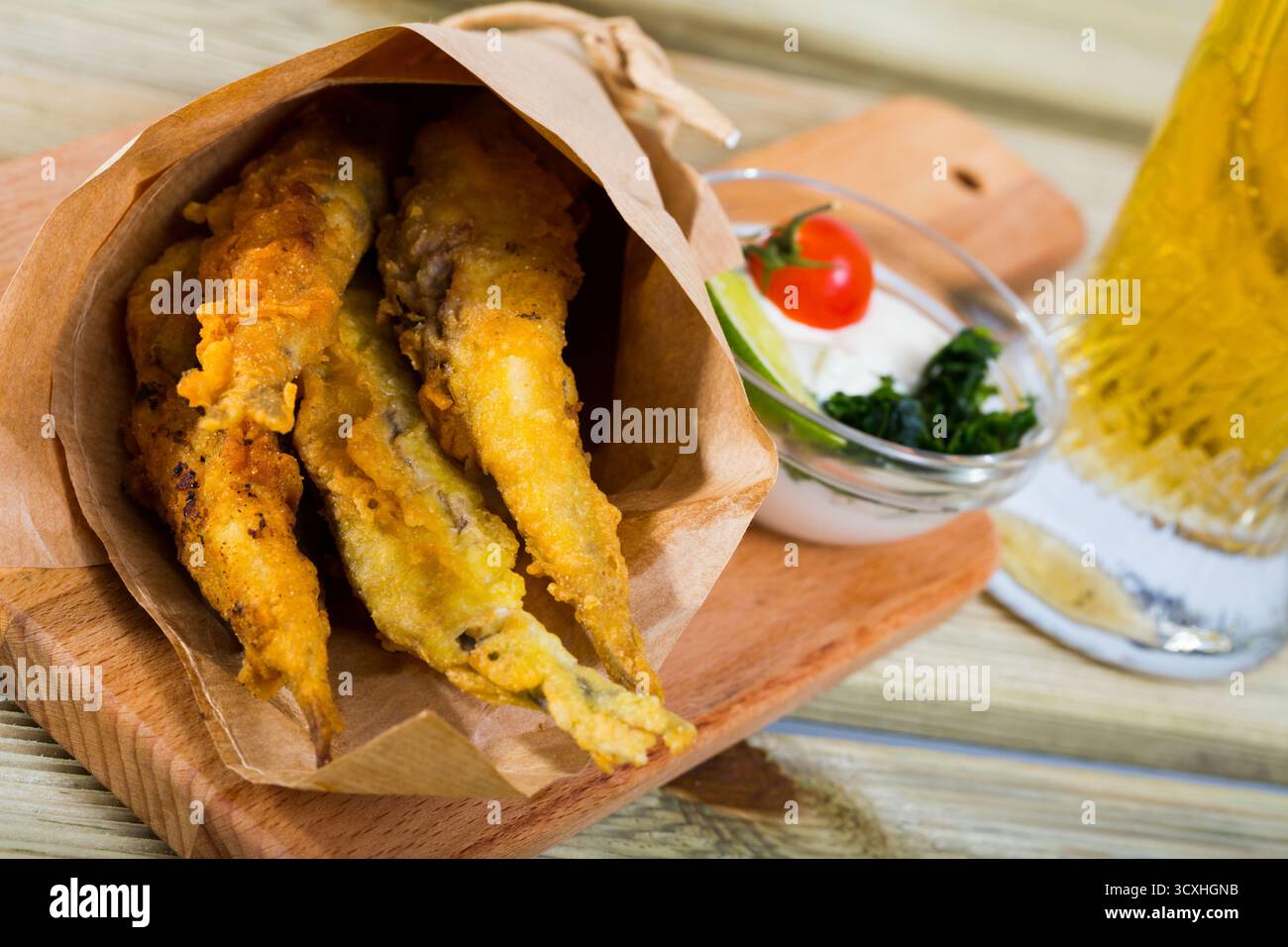 Acciughe fritte in padella con salsa cremosa al formaggio, verdure Foto Stock