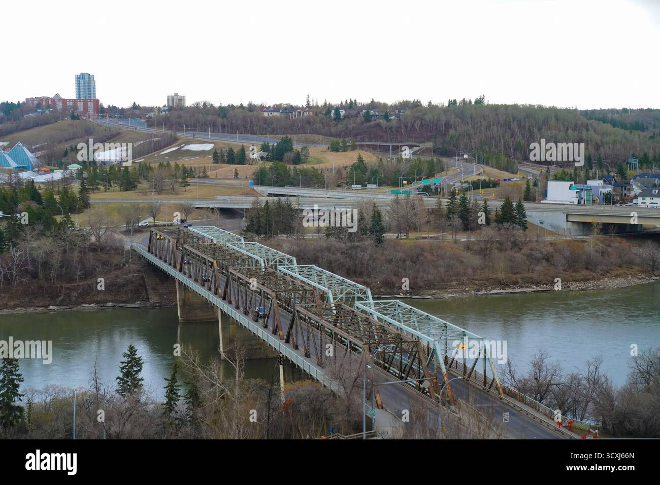 Veduta del ponte a capriata in metallo e della rete stradale circondati da colline ondulate e vegetazione, che catturano infrastrutture, pianificazione urbana e architettura bilanciata Foto Stock