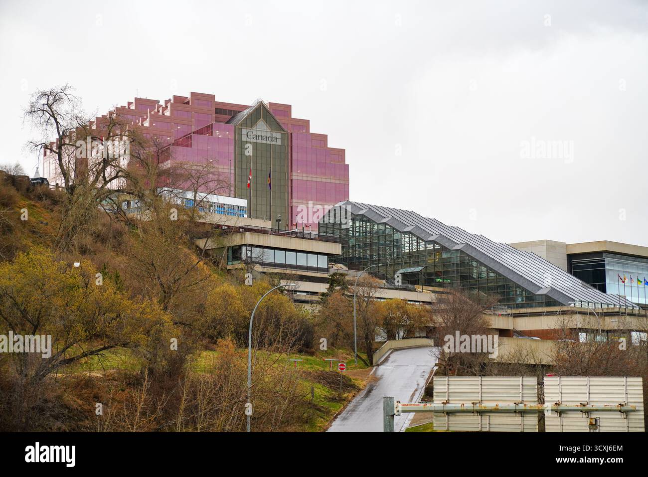 Canada Place con la sua caratteristica facciata in vetro rosa sorge sopra la valle del fiume, mostrando architettura moderna in una nuvolosa giornata primaverile Foto Stock