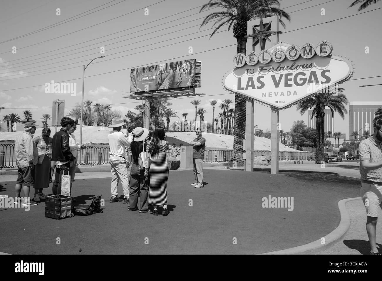 I turisti si posano per delle foto di fronte al cartello "Welcome to Fabulous Las Vegas" in un'immagine in bianco e nero che cattura un momento senza tempo di cultura di viaggio Foto Stock
