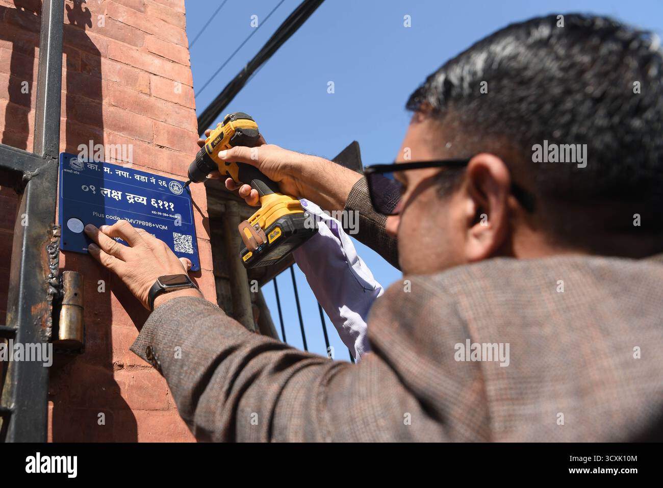 Kathmandu, Nepal. 15 ottobre 2025. Kathmandu Metropolitan City (KMC) lancia un sistema di indirizzi digitali basato su chip NFC nelle case all'interno del reparto n. 26. Il progetto, inaugurato presso l'ufficio distrettuale di Kathmandu il 15 ottobre 2025, è finanziato con 4,5 milioni di NPR e mira a completare l'installazione in tutte le famiglie entro un mese. Foto: Safal Prakash Shrestha credito: Safal Prakash Shrestha/Alamy Live News Foto Stock