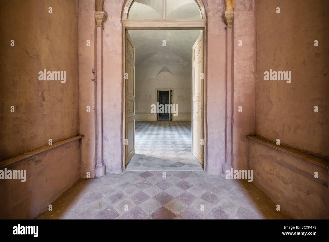 Edificio storico abbandonato interno con porte aperte e piano a scacchi Foto Stock
