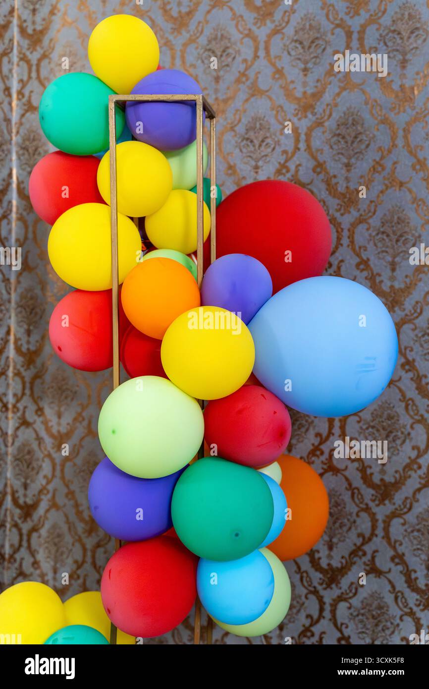 Festa dei palloni colorati contro il muro degli arazzi d'oro. Foto Stock