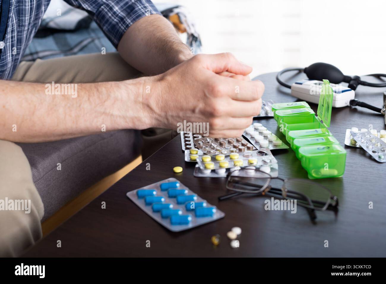 Uomo caucasico di mezza età che prende pillole da pillbox Foto Stock