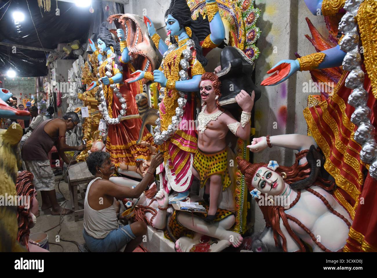 Kolkata, India. 14 ottobre 2025. Un artigiano dà i tocchi finali a un idolo della dea indù Kali alla vigilia della festa indù di Diwali a Kumortuli, il quartiere tradizionale dei ceramisti nel nord di Kolkata il 14 ottobre 2025. - (Foto di Dipa Chakraborty/Pacific Press) credito: Pacific Press Media Production Corp./Alamy Live News Foto Stock