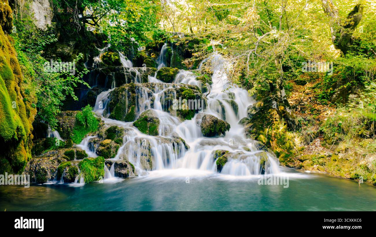 Effetto acqua uniforme che cattura il movimento di una cascata di montagna pulita nella foresta Foto Stock Effetto acqua uniforme che cattura il movimento di una cascata di montagna pulita nella foresta Foto Stock